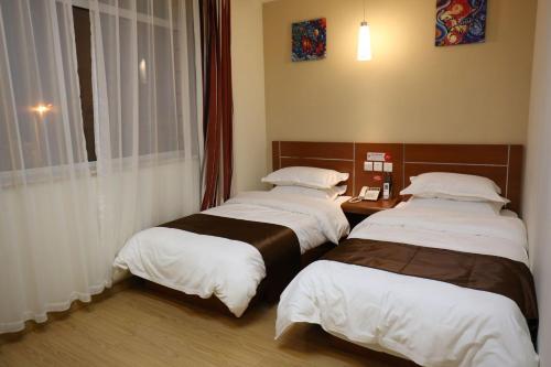 3 camas en una habitación con ventana en Thank Inn Chain Hotel Hebei Langfang Guan Bus Station, en Liuquan