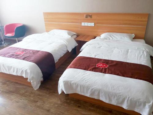two beds in a hotel room with a red chair at Thank Inn Chain Hotel Hebei Cangzhou Dongwaihuan International Hardware Plaza in Cangzhou