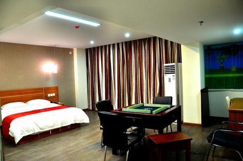 una camera con letto e scrivania con scrivania di Thank Inn Chain Hotel Henan Xinyang Shangcheng County Huayuan Road a Shangcheng