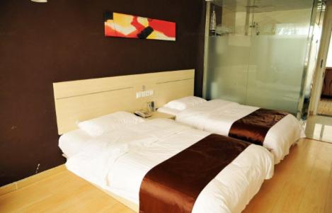 two beds in a hotel room with a shower at Thank Inn Chain Hotel Shandong Zibo Zichuan Luzhong International Shopping mall in Zibo