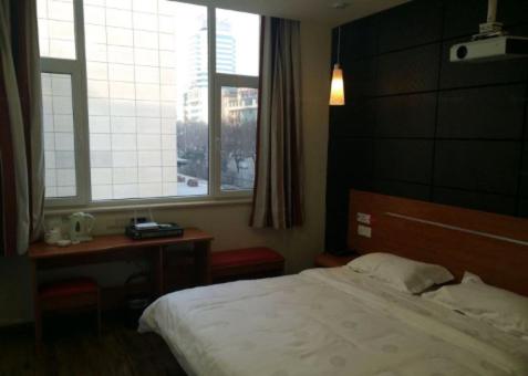 um quarto com uma cama, uma secretária e uma janela em Thank Inn Chain Hotel Shangxi Changzhi Daqing Road em Changzhi