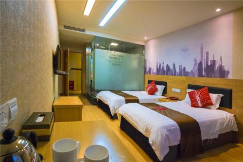 a hotel room with two beds and a large screen at Thank Inn Chain Hotel Sichuan Guangan Wusheng County Hongwu Avenue in Wusheng