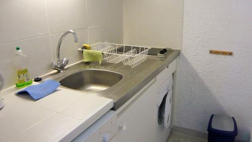 um lavatório de cozinha com um suporte para secar pratos ao lado em 3CPF29 Appartement avec jardinet et parking, proche centre-ville em Collioure