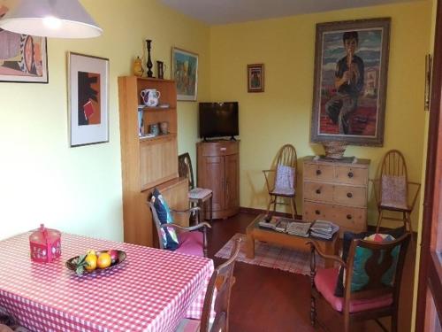 a living room with a table and chairs and a television at 5VSE-LAM56 Appartement avec vue sur la baie in Collioure