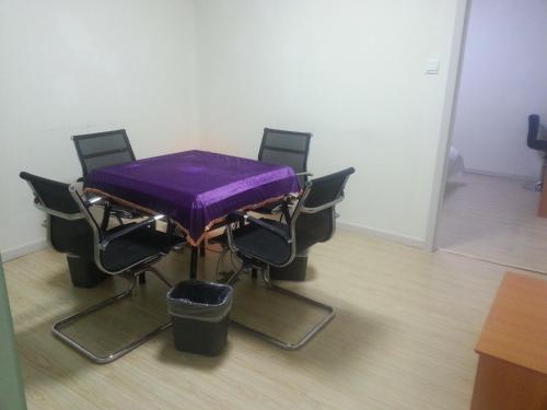 a table with chairs and a purple table cloth on it at Thank Inn Chain Hotel Jiangsu Wuxi New District Taibo Avenue in Wuxi