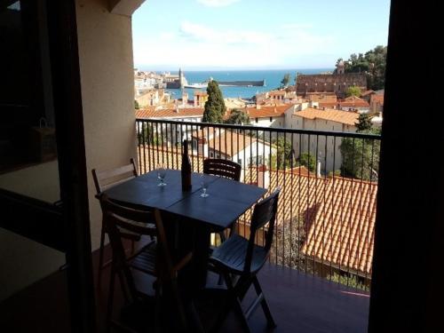 a table and chairs on a balcony with a view at 5VSE-LAM56 Appartement avec vue sur la baie in Collioure