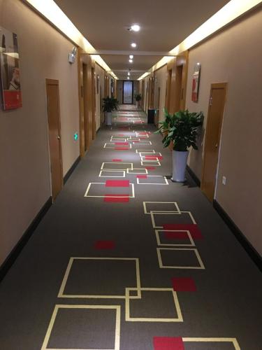 a hallway in a building with red and yellow flooring at Thank Inn Chain Hotel Sichuan Dazhou Tongchuan Dis. Railway Station in Dazhou