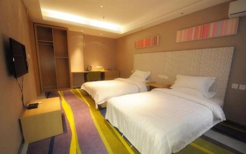 a hotel room with two beds and a television at JUNYI Hotel Hebei Xingtai Qinghe West Wusong Road in Xielu