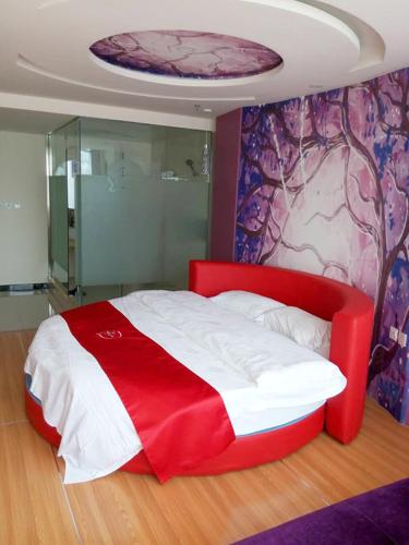 a red and white bed in a room at Thank Inn Chain Hotel Hebei Cangzhou Dongwaihuan International Hardware Plaza in Cangzhou