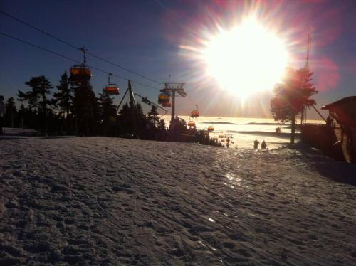 a ski slope with a ski lift and the sun at Chalupa Denis & Marek in Kovářská