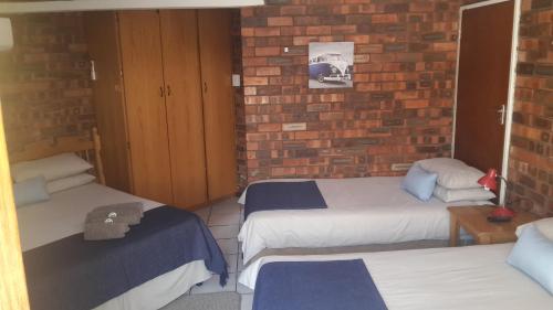 a room with two beds and a brick wall at The Highland Inn in Bethlehem