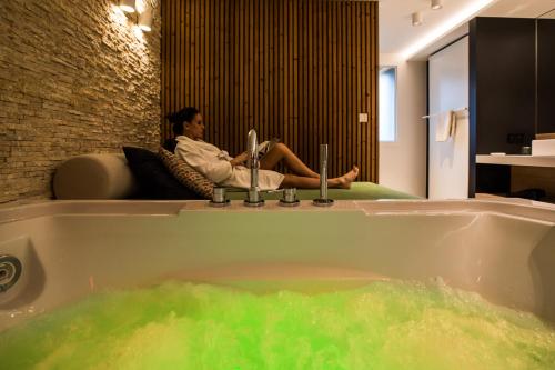 a woman sitting on a couch in a bath tub at Wellness Hasselt B&B in Hasselt