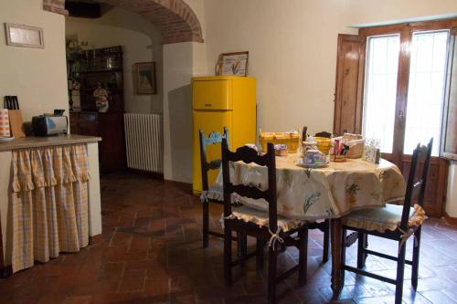 a kitchen with a table and a yellow refrigerator at Agriturismo Podere San Pietro in Montepulciano