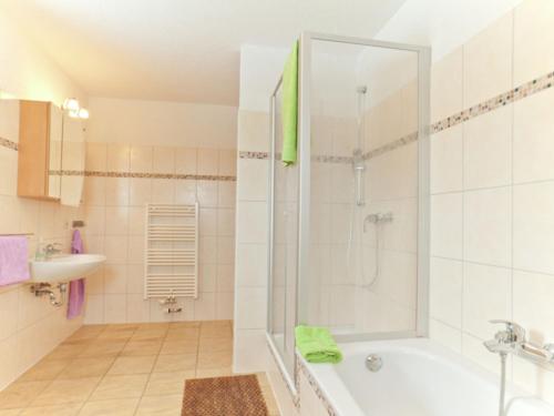 y baño con ducha, bañera y lavamanos. en Comfortable Holiday Home in Satow near Baltic Coast, en Satow