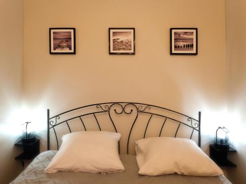 ソポトにあるBeach Apartment I Plażowy Happy Hoursのベッド1台(枕2つ、壁に3枚の写真付)