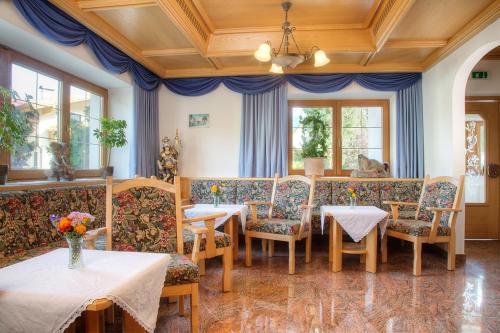 a dining room with tables and chairs and windows at Gasthof Ascherwirt in Brandenberg