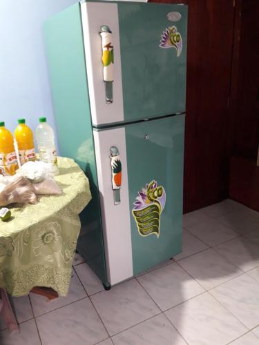 a refrigerator with stickers on it next to a table at Weligama Bay Eco Villa in Weligama