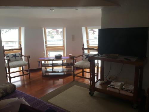 een woonkamer met 2 stoelen en een flatscreen-tv bij Villa Alessandra in Colle Isarco