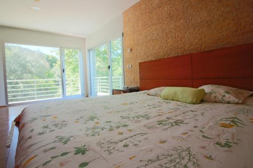a bedroom with a large bed with a large window at Casa de Paredes Secas by Gerês Casas in Amares