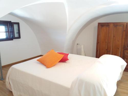 a bedroom with a white bed with an orange pillow at Casa salento in Corsano