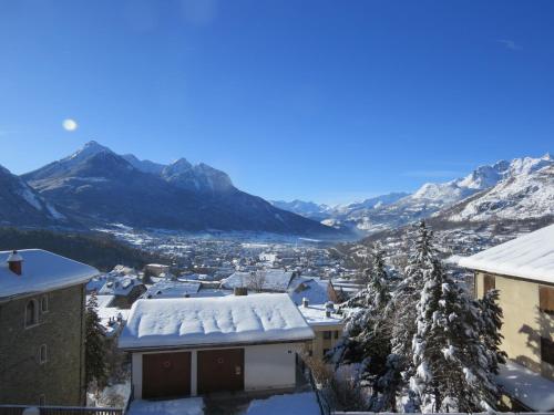a city covered in snow with mountains in the background at Horizon Vauban in Briançon