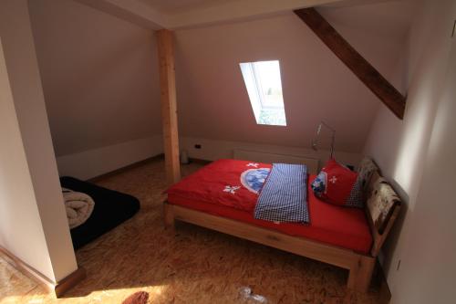 a bedroom with a red bed in a attic at Haus Seeblick Bestensee in Bestensee