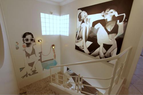 a bathroom with a large picture on the wall at Casa do Artista a 60m do mar, piscina, 4 quartos in Bombinhas