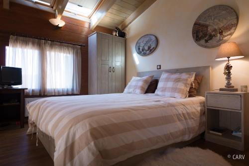a bedroom with a large bed and a television at Kallisto Mountain House II in Arachova