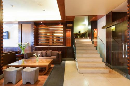 a lobby of a hotel with a staircase and a table at Le Commodore Hotel in Beirut