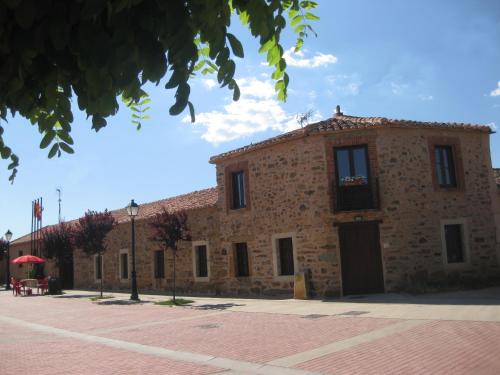 un gran edificio de piedra con una bandera encima en Casa Rural Las Águedas, en Murias de Rechivaldo