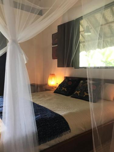 a bedroom with a bed with a white canopy at Reserva Natural Tierra Adentro in Minca