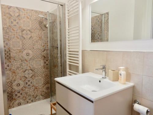 a white bathroom with a sink and a shower at Appartamento Abate in Lido di Camaiore