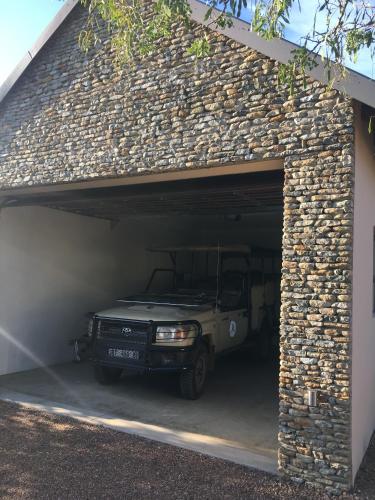 a jeep parked inside of a stone garage at MANZINI RIVER HOUSE - Mjejane Private Game Reserve, Greater Kruger National Park in Hectorspruit