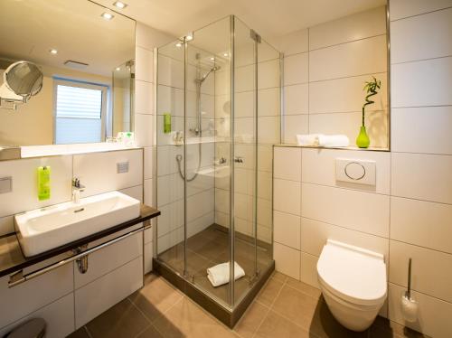 a bathroom with a toilet and a sink and a shower at sevenDays Hotel BoardingHouse Mannheim in Mannheim