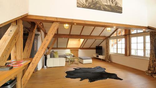 キッツビュールにあるAppartement Kitzbühel mit Dachterrasseの木製の梁のあるロフト付きの広い客室です。