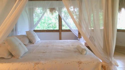 命卡的住宿－Minca Glamping，一间卧室配有带窗帘的床和窗户