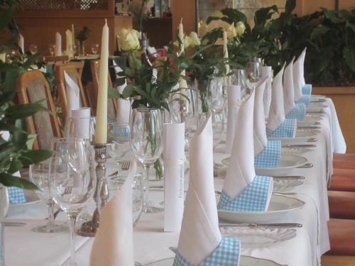 a long table with plates and glasses and flowers on it at Landgasthof Hotel Muhr in Gallbrunn