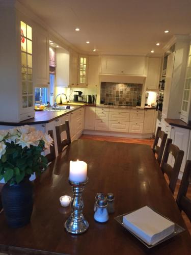 a kitchen with a table with a candle on it at Idyllisk sørlandshus in Risør