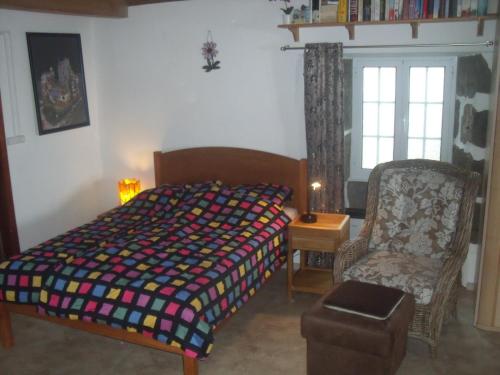 a bedroom with a bed and a chair and a window at Casa Bianca in Lajes das Flores