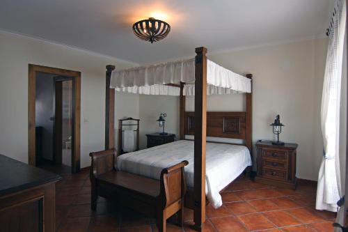 a bedroom with a canopy bed with a desk and a chair at Paradise Valley House in São Martinho do Porto