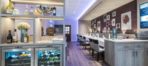 a restaurant with a bar with bottles of wine at Hotel Monika in Büttelborn