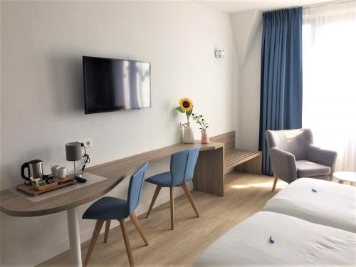 a hotel room with a table and chairs and a bed at Hotel Bosch En Zee in Domburg