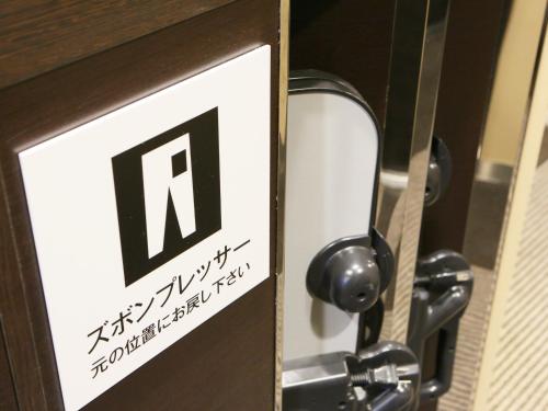 a sign on a door with the letter n on it at APA Hotel Chiba Yachiyo Midorigaoka in Yachiyo