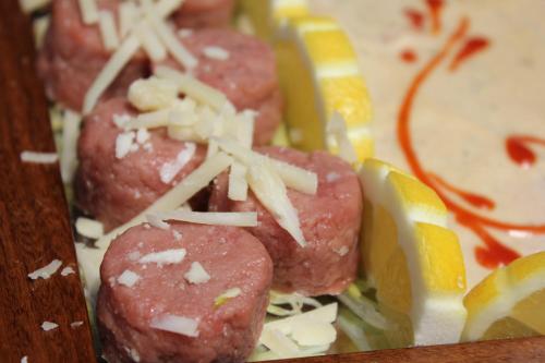 a plate of food with meatballs and lemon slices at Villa Soleil in Colleretto Giacosa