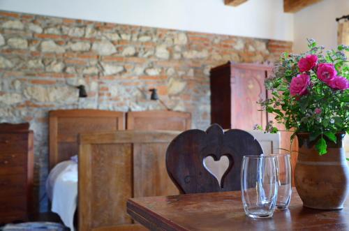 a wooden table with a vase of roses on top of it at Bagolyvár Fogadó- Újfalusy Márton Vendégház in Zirc
