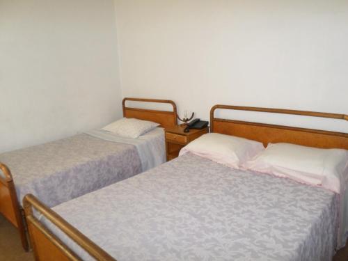 Cette chambre comprend 2 lits et un téléphone. dans l'établissement Rustico & Singelo - Hotelaria e Restauração, Lda, à Vila Real