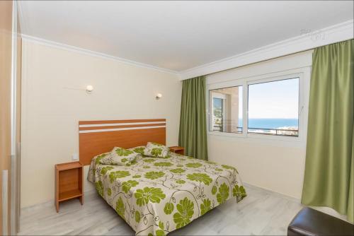 a bedroom with a bed and a large window at Frente al mar in Benalmádena