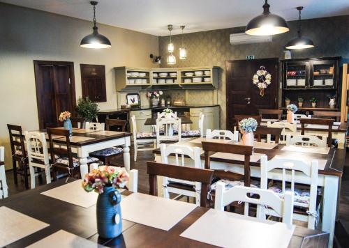 a restaurant with wooden tables and white chairs at Kalvín Restaurant & Pension in Rastislavice