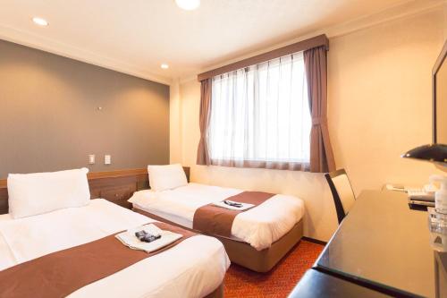 En eller flere senge i et værelse på Shimizu City Hotel
