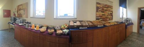 a bakery with a counter with different types of bread at Hotel Pombeira in Guarda